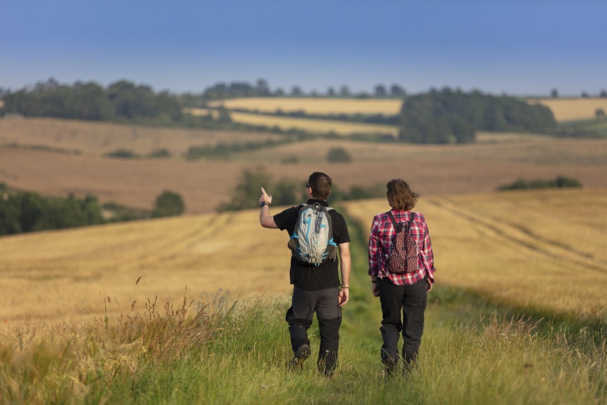 A man and a woman walking through fields in the Lincolnshire Wolds