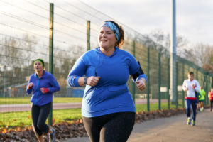 A lady running and jogging with other people