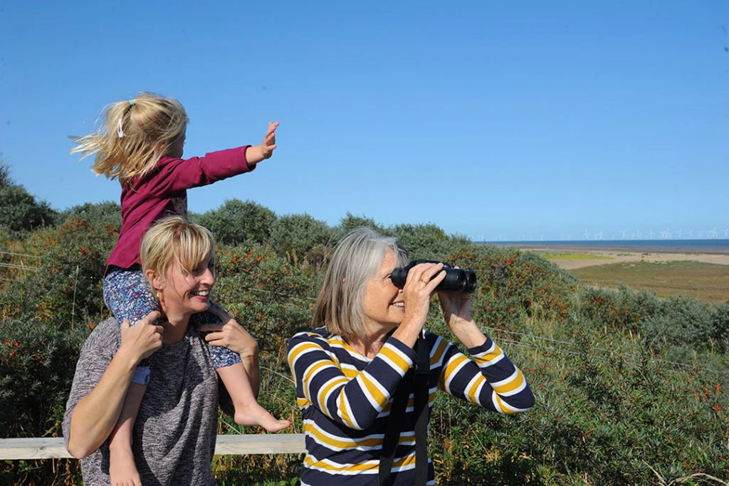 Two ladies, with a young toddler on one of their shoulders