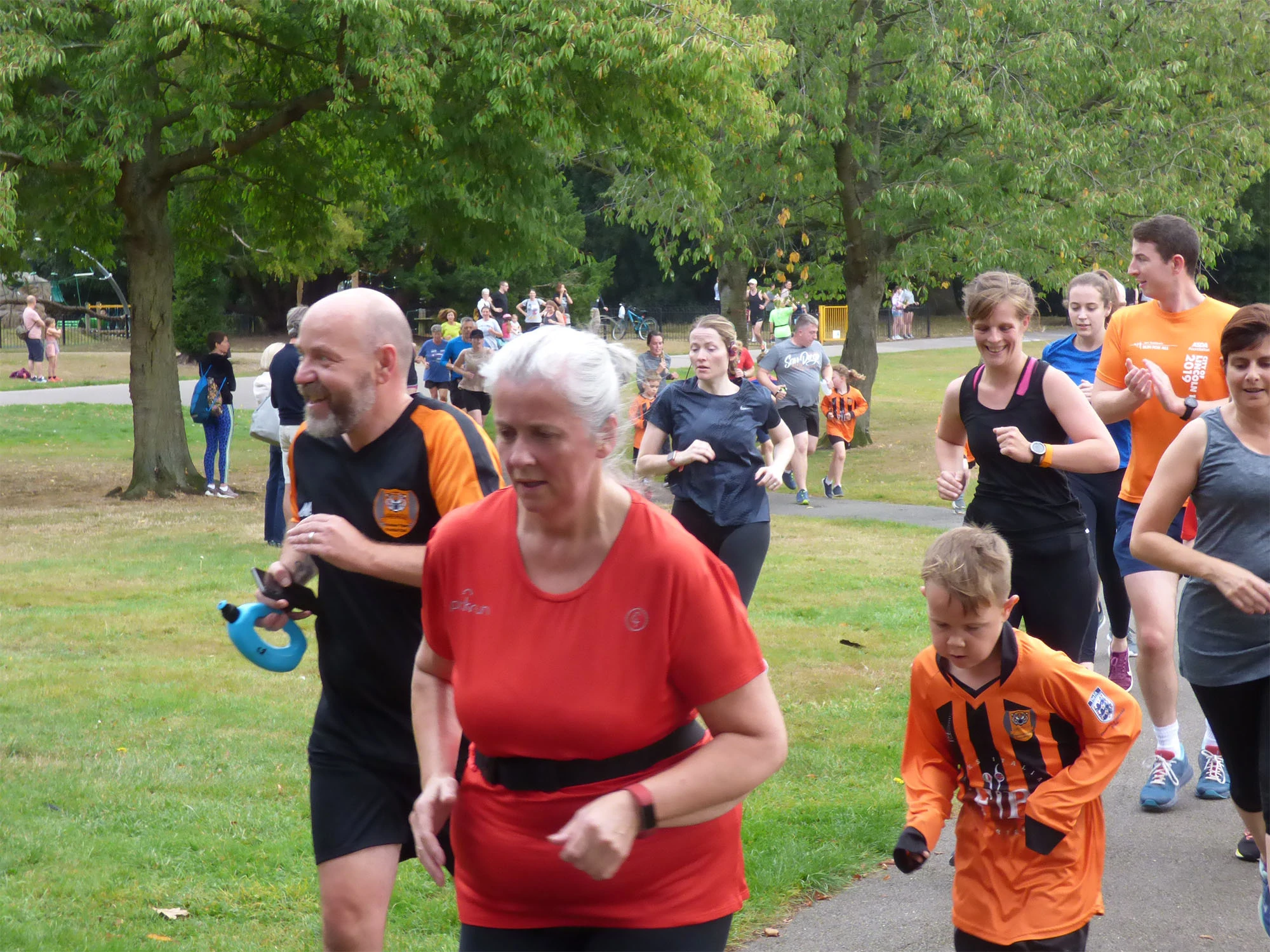people of different ages running and jogging in a park