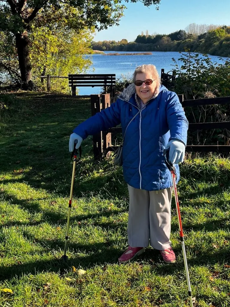 Image of lady with walking poles in front of lake