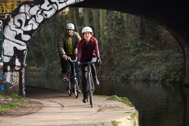 man and women cycling along a canal path
